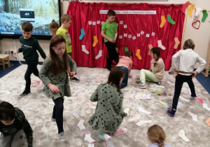 21 dzieci układają kolorowe skarpetki na dywanie.jpg